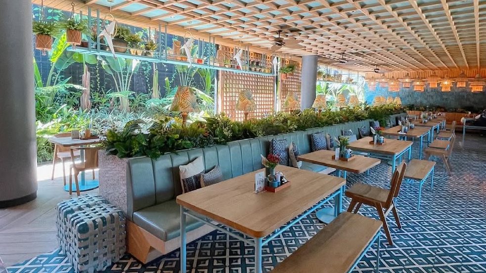 Interior of Kedai Soto Ibu Rahayu Bogor, showcasing blue and white tiled walls and rustic wooden tables.