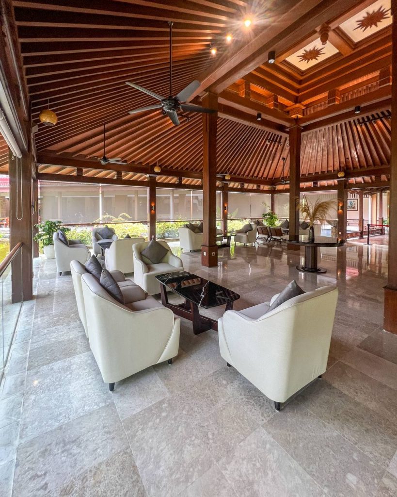 Spacious open-air lobby with comfortable seating and elegant wooden architecture.
