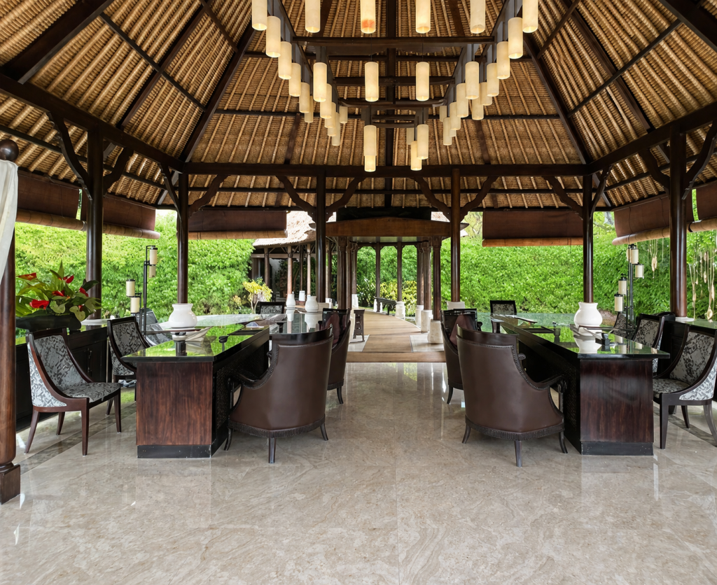 Elegant open-air pavilion with dark wood furnishings, hanging lantern lights, and lush greenery surrounding the space.